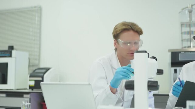 Scientists conduct experiments in lab using microscope and data sheets for research analysis