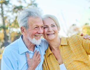 Happy active senior couple taking selfie sitting ob a bench in park outdoors. Love togetherness and...