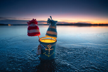 cold frozen sea in winter with a lantern and self knitted hat