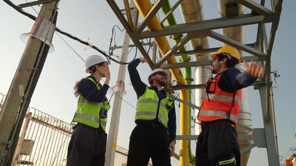 Workers discuss plans and safety measures at construction site during day