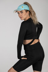 A woman in a tracksuit is practicing finesse. A woman is doing rhythmic gymnastics.