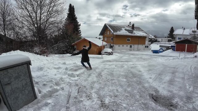 Video Rutschgefahr auf einem glatten Gehweg im Winter. Eine Frau rutscht auf einer schneeglatten Stra&szlig;e aus