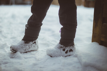Low section of person standing on snow covered field
