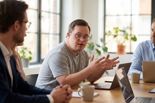 Male professional with Down Syndrome actively participates in a business meeting