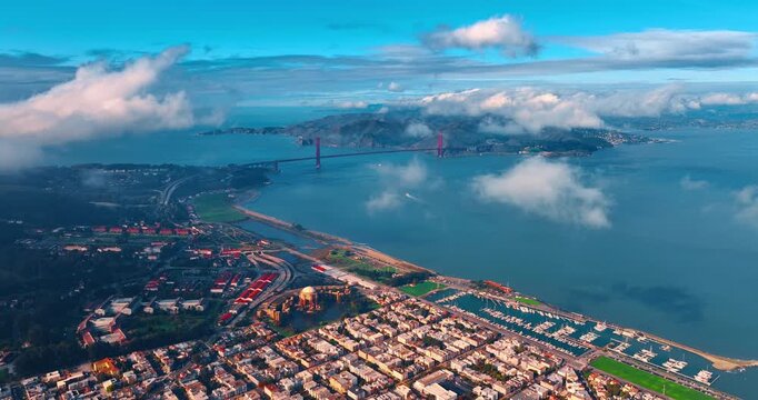 Spectacular perspective on San Francisco Bay and cityscape at the waterfront. View on the gorgeous Golden Gate Bridge linking San Francisco and Marin. Clouds spread in the sky over the scenery.
