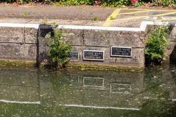 Plaques marking flood heights in 1894, 1947 & 2003 on Osney Lock on the River Thames at Osney, Oxford, England UK