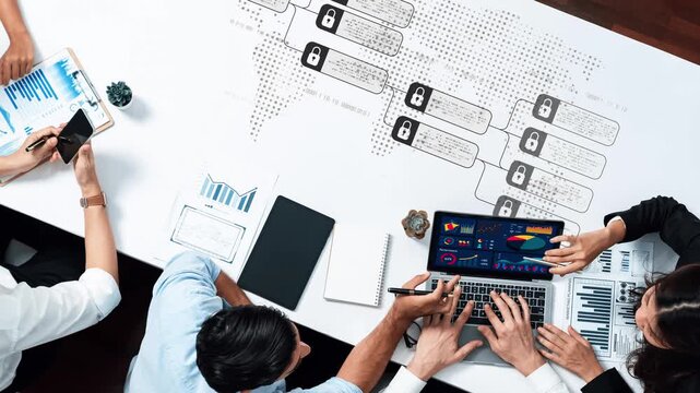 A diverse business team engages in a data analysis session with charts and graphs on the laptop, showcasing teamwork and strategic planning in a modern workspace. Raster