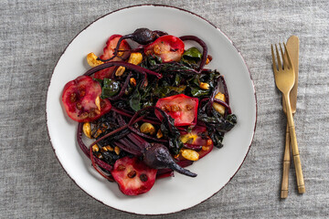 Delicious salad of roasted beetroot stalks with apples and peanuts, garlic and raisins