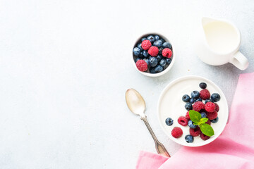 Yogurt with fresh berries in white bowl.