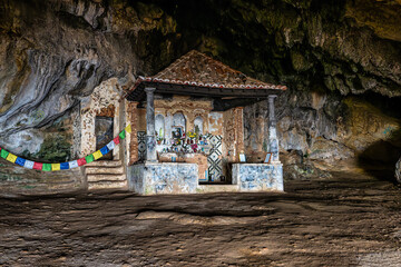 Dark interior of Lapa de Santa Margarida in Arrabida, Setubal, Portugal. Cave with small chapel of spontaneous worship