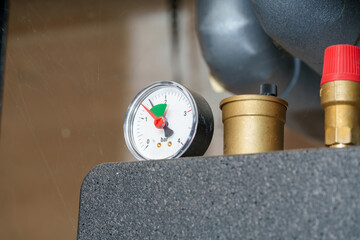 Pressure gauge on equipment showing measurement in bars with surrounding components in workshop setup
