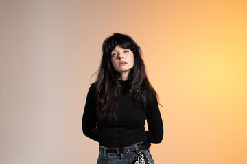 A young brunette woman poses for a photographer and looks at the camera.