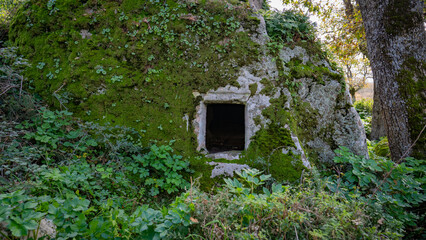 Prehistoric nuraghe stone structure rising from green landscape under dramatic sky in Sardinia