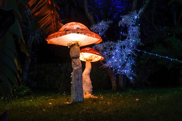 Large artificial mushrooms illuminated at dusk.