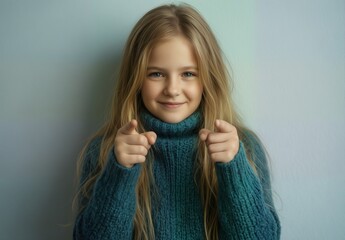 adorable young girl in a cozy blue sweater pointing at the viewer with a cheerful expression.
