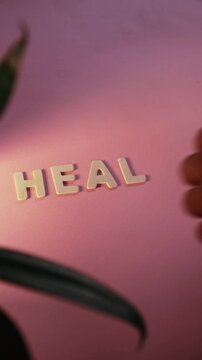 Person spelling the word heal with letters