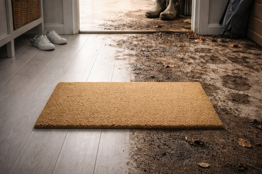 The contrast of a clean rug and a dirty floor at the front door.