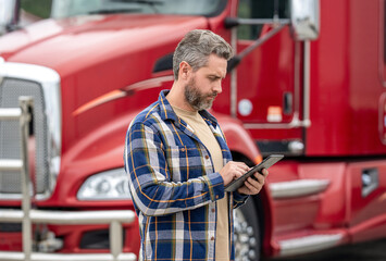 Service diagnostics for truck. Man use tablet to configure equipment. Automated logistics online...
