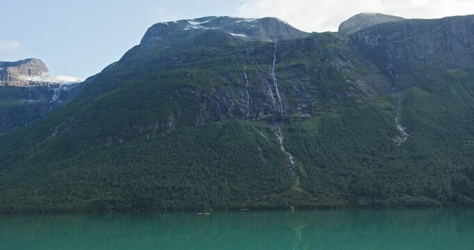 Waterfalls above turquoise Lovatnet Lake, Loen, Norway summer mountain landscape