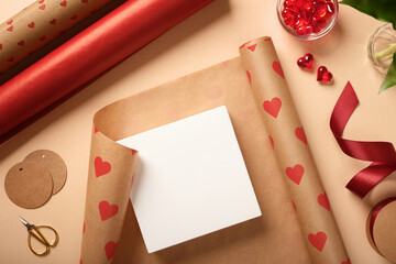 Unpacked box is on wrapping paper. Around ribbon, scissors, gift labels, and hearts. Preparing for the holidays.