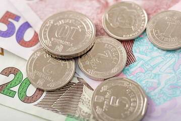 Ukrainian coins and banknotes background. Group of hryvnia coins on paper bills. Financial growth and national currency concept.