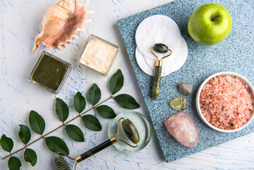 Natural spa skincare flat lay with jade rollers crystals sea salt and apple