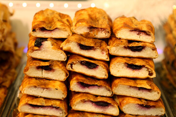 Homemade strudel filling with cottage cheese cream. Pile of traditional strudels from Hungary. Hungarian strudel r&eacute;tes on market stall for sale