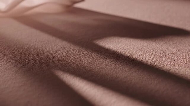Closeup view of beige fabric texture with soft shadows and light highlights creating depth