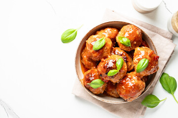 Meatballs in tomato sauce on white background.
