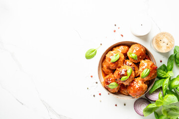 Meatballs in tomato sauce on white background.