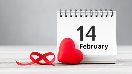 Calendar with the date February 14th highlighted and a red heart, a symbol of Valentine's Day, love, and romance.