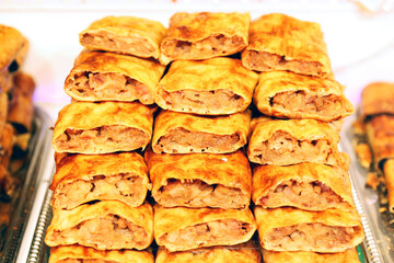 Homemade strudel filling with apple cream. Pile of traditional strudels from Hungary. Hungarian strudel  r&eacute;tes on market stall for sale