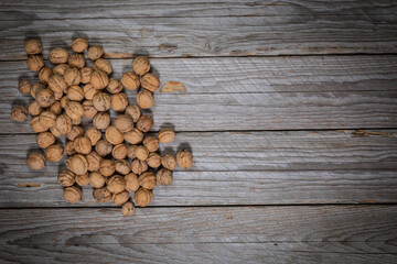 Top-down studio shot of whole walnuts on weathered wooden boards
