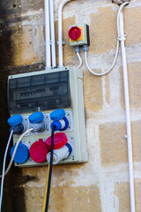 Industrial Electrical Panel and Wiring Box Mounted on Outdoor Wall with Utility Sockets and Conduits