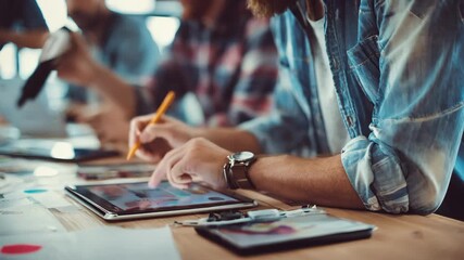 Closeup of creative team designing unique digital assets on hightech tablets emphasizing innovation in branded merchandise creation. - Powered by Adobe