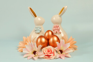 Happy Easter concept. Abstract spring Easter composition with golden painted eggs, spring lotus and rose flowers, and a holiday greeting card. Screen banner with space for congratulatory text