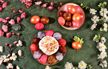 Traditional kulich and marbled Easter eggs painted with onion peel, hibiscus tea and pink matcha with sakura branches, Easter celebration concept, Easter dish ideas for home cooking