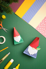 Crafts paper gnomes with art supplies. DIY background.