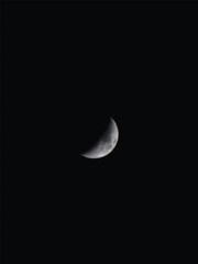Clear crescent moon glowing in the dark black night sky with copy space.