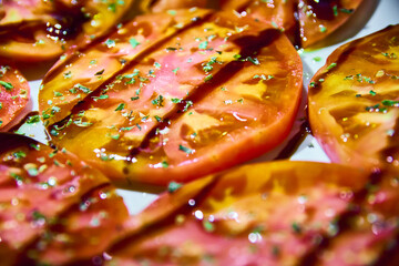 Sliced tomatoes with olive oil, balsamic vinegar and oregano close-up