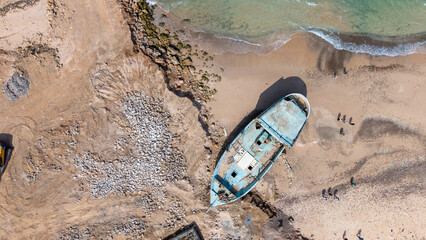 Stranded blue boat on sandy beach