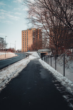 View of a modern concrete underpass and road in Elineberg, featuring brick apartment towers and snowy embankments.