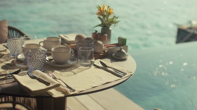 Luxurious breakfast table for three set over the turquoise waters of a tropical resort