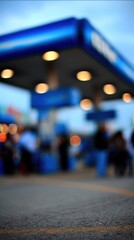 Fototapeta premium Blurred fuel station background at night representing urban mobility and energy.