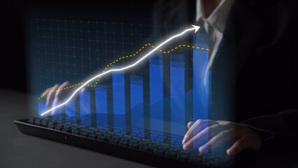 A business professional engages with a digital display of financial graphs and data analytics while using a keyboard in a modern office setting. Copula