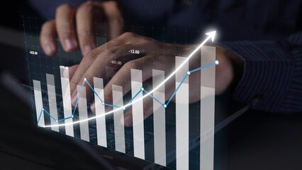 Hands typing on a laptop with a vibrant graph overlay, illustrating positive financial growth trends in a dynamic business setting, capturing the essence of modern analysis. Copula
