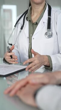 Doctor woman consulting patient, filling out medical records during a healthcare check up in a clinic. Medicine, healthcare and science concept