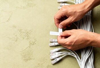 IT technician labeling network ethernet cables for installation. Data center cable management and organization. Top view with copy space