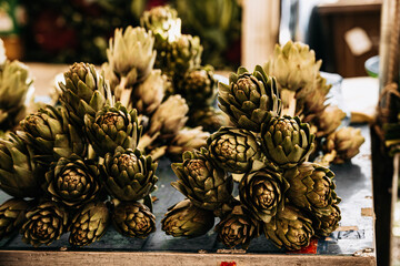 Fresh Green Artichokes At Market Stall: Raw Seasonal Vegetables With Leaves And Stems Displayed In...