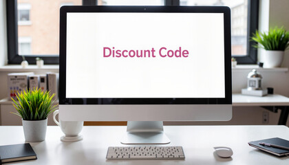 Sleek computer displaying discount code on office desk, promotional offer